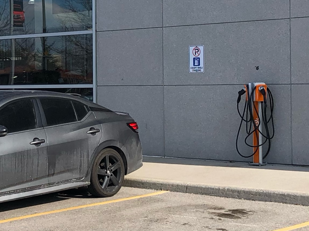 Electric vehicle charging station at a workplace or multi-residential building with the text 'Workplaces / Multi Residential' inviting visitors to explore ChargerCrew's services for these industries.